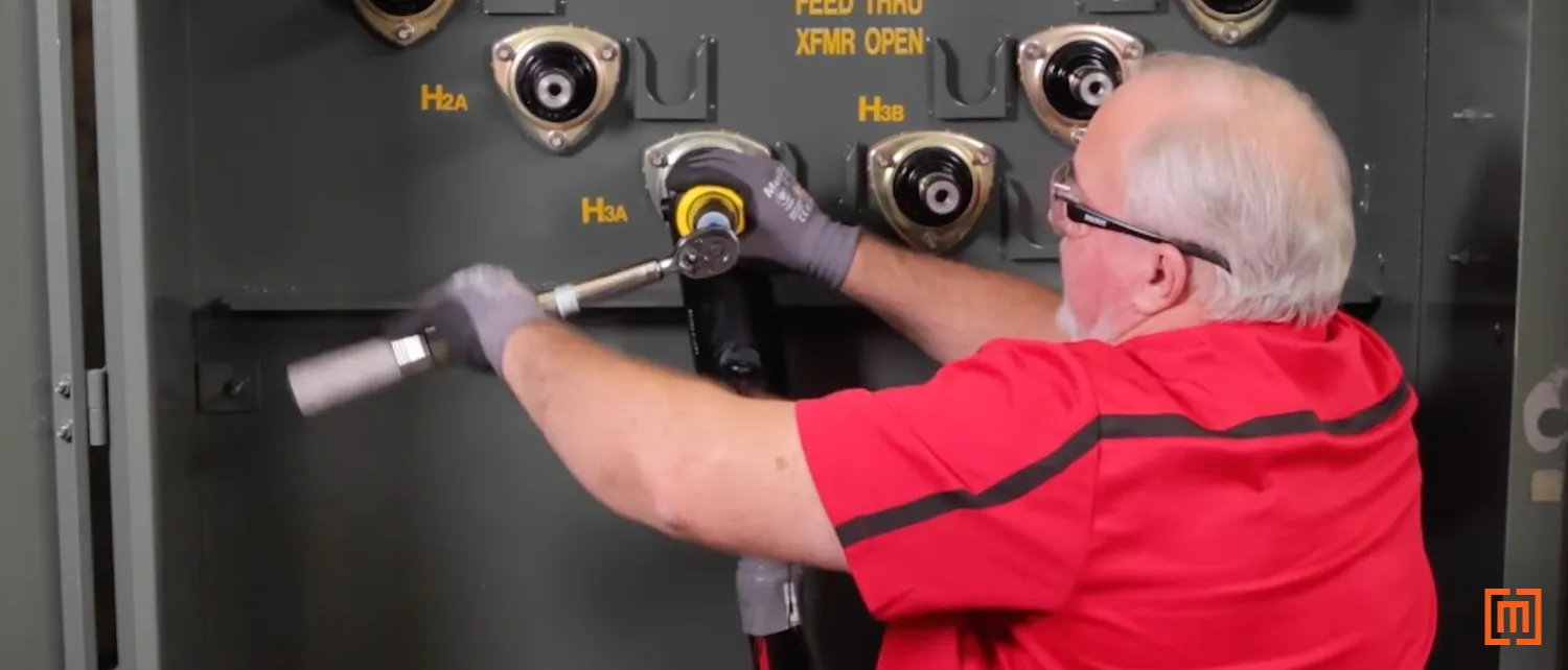 Technician torquing 200 amp tap lug with a 5/16 allen wrench.
